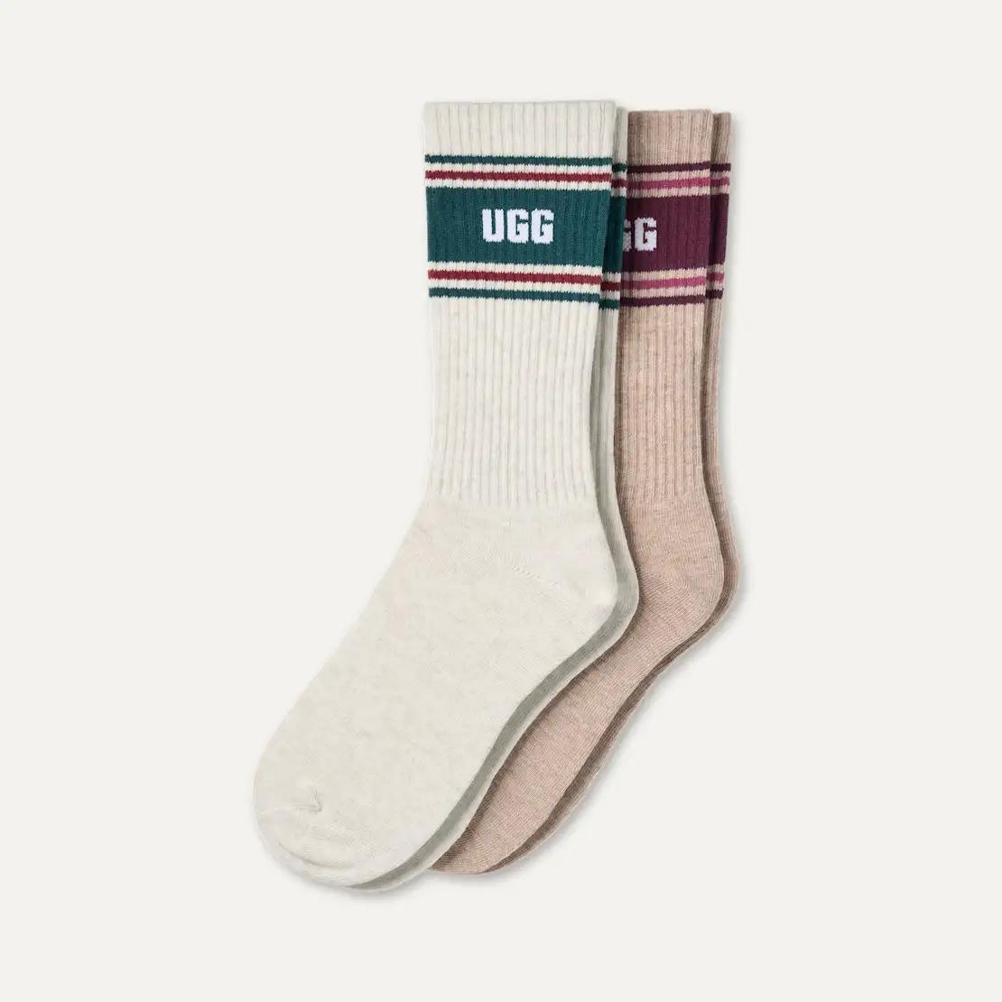 Two UGG Jedlyn crew socks, one cream and one beige, featuring striped cuffs with the brand name 'UGG' in white.