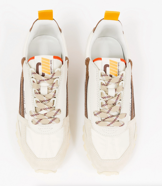 A pair of Off-White low-top Oncept sneakers shown from a top-down view on a clean white background. The sneakers feature an off-white leather upper with brown suede side panels, beige and brown striped laces, and a white tongue label with orange and yellow graphic details.