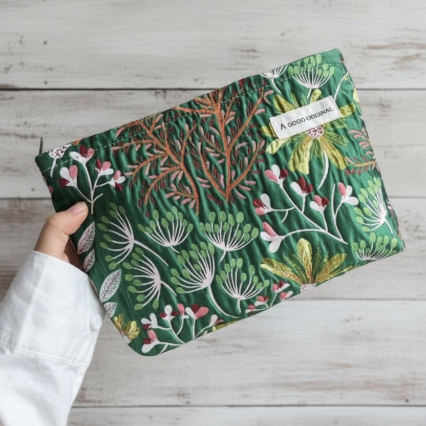 Green cosmetic bag with botanical floral print and zip‑top closure.