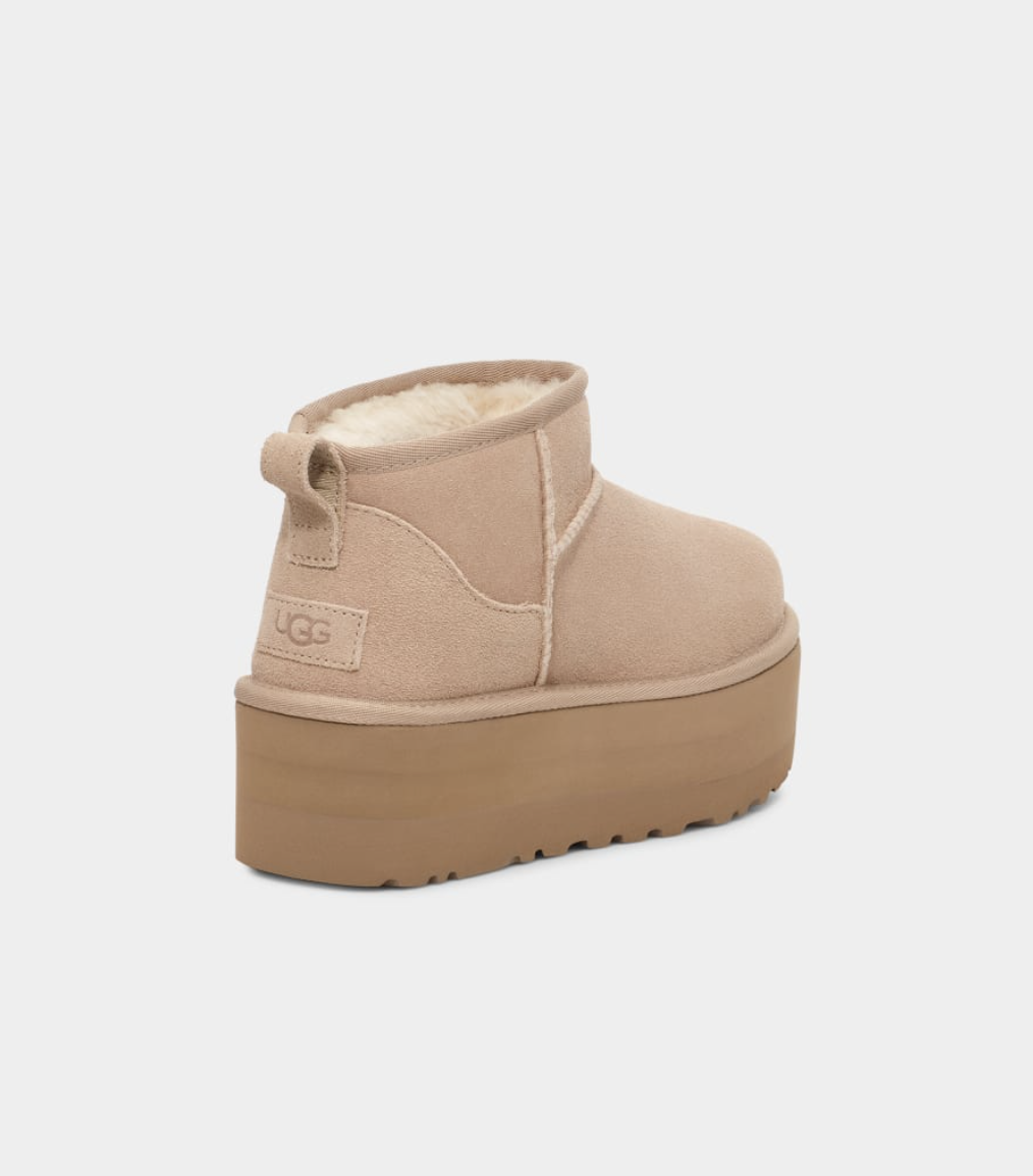 Women’s UGG Classic Ultra Mini Platform boot in sand suede with plush sheepskin lining and a 2-inch platform sole.