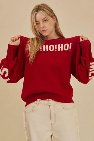 Person wearing a red sweater with 'HO! HO!' text on a beige background