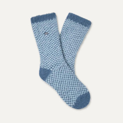 A pair of light blue and medium blue patterned UGG Enlie crew socks with solid blue heels, toes, and cuffs, displayed on a light cream background.