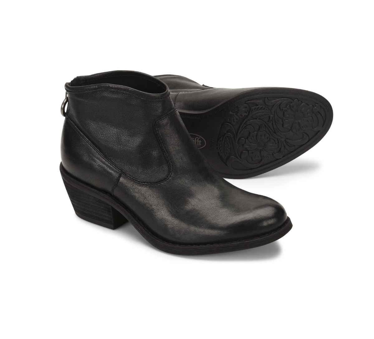 A pair of Sofft Aisley black leather ankle boots, with one boot standing upright to show the side and heel, and the other lying flat to display the decorative floral embossed outsole.