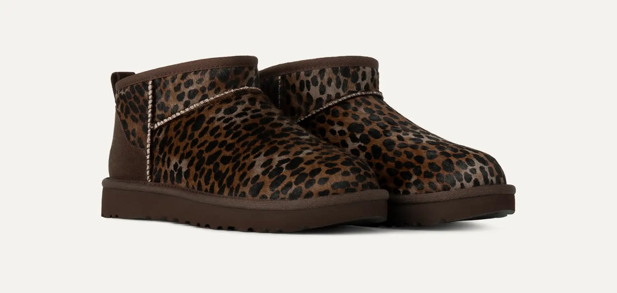 Pair of leopard print boots on a white background