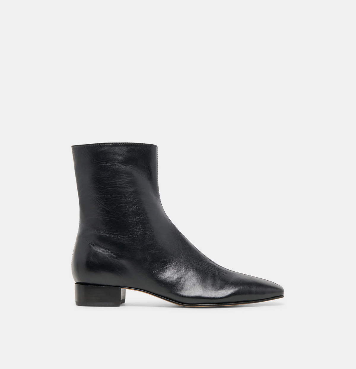 A single Dolce Vita Tarine  black leather ankle boot with a pointed toe and low block heel, shown in profile against a light gray background.