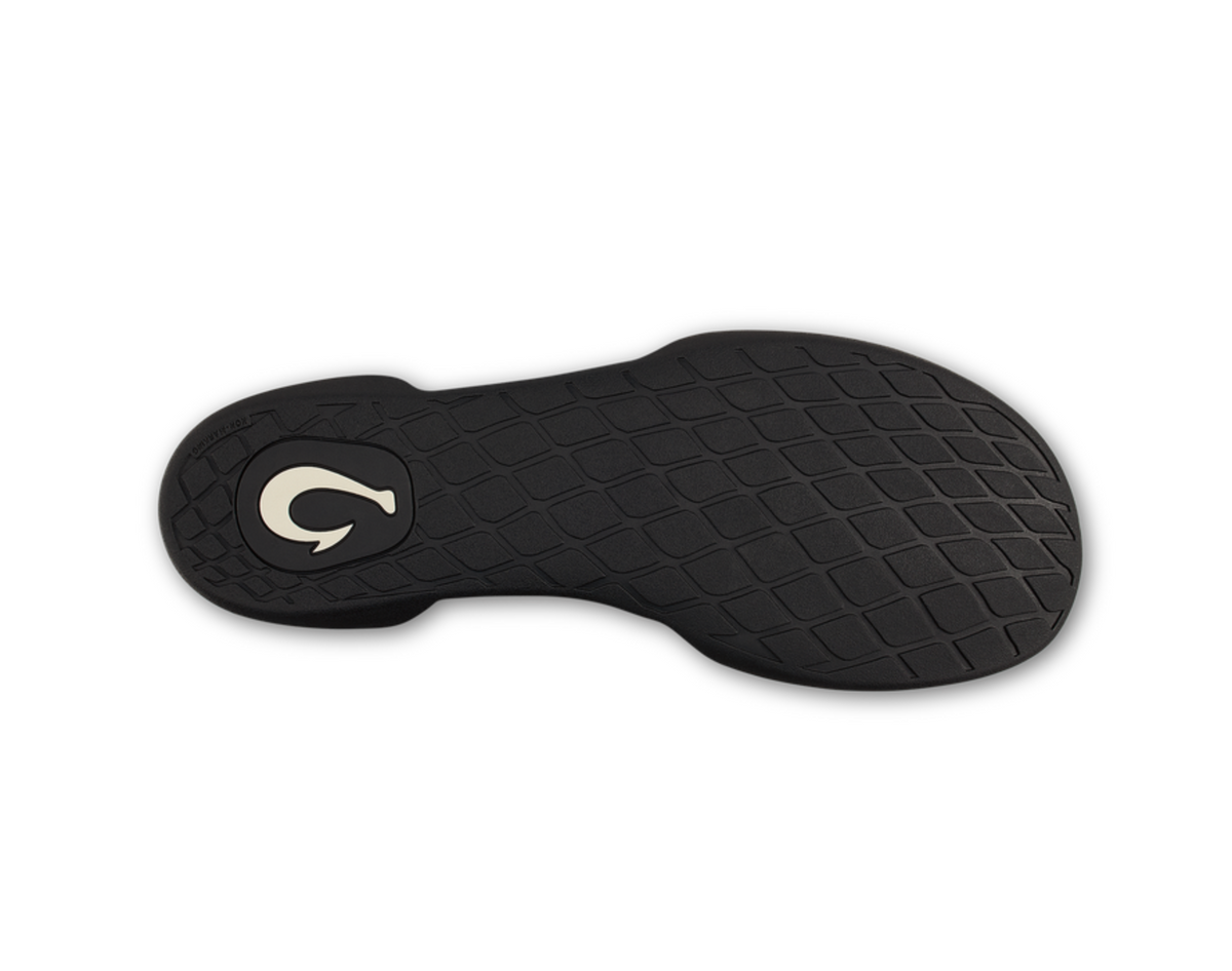 A Olukai Moloa Hulu black textured shoe insole or footbed shown from the bottom side, featuring a repeating diamond pattern and a small white stylized logo near the heel, on a plain white background.
