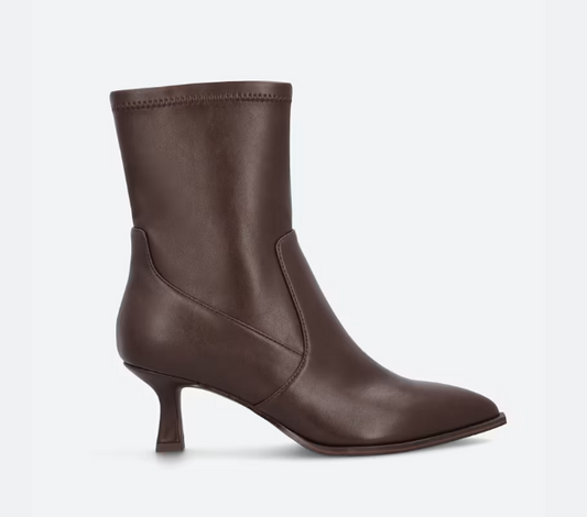A DV Lalana dark brown leather ankle boot with a pointed toe and a short kitten heel, shown from a side profile on a light gray background.