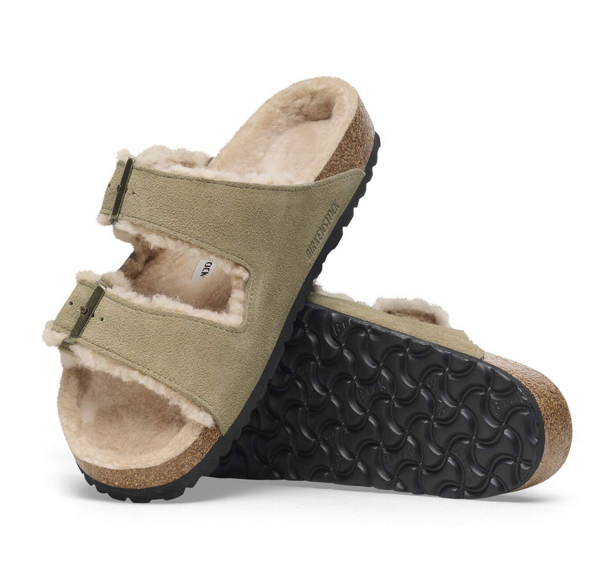 Pair of Birkenstock Arizona shearling beige sandals with black soles on a white background