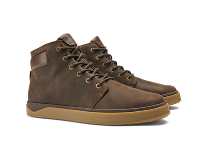 A pair of Olukai Kekaha mid-top brown leather boots with tan soles and brass eyelets, shown on a clean white background.