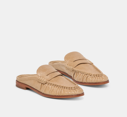 A pair of women's Dolce Vita Betzy slip-on loafers in a textured tan leather, shown from a three-quarters angle on a light gray background.