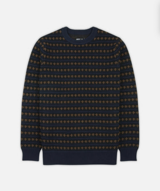 A Jetty Fairisle Stripe navy blue crewneck sweater with horizontal stripes of gold geometric patterns, displayed flat against a light gray background.