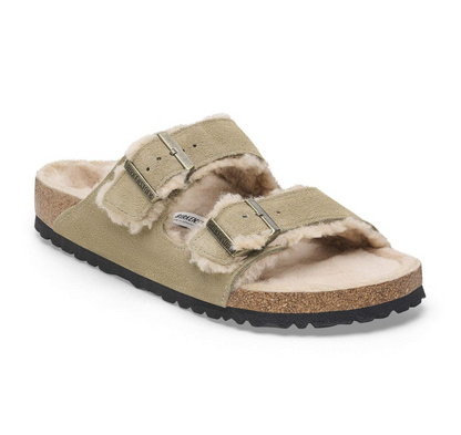 A single Birkenstock Arizona shearling sandal in taupe suede with a plush cream shearling lining, featuring two adjustable straps with silver buckles and a cork midsole.