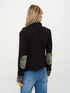 A woman shown from the back wearing a black cropped jacket with distressed denim elbow patches and blue jeans, against a plain white background.