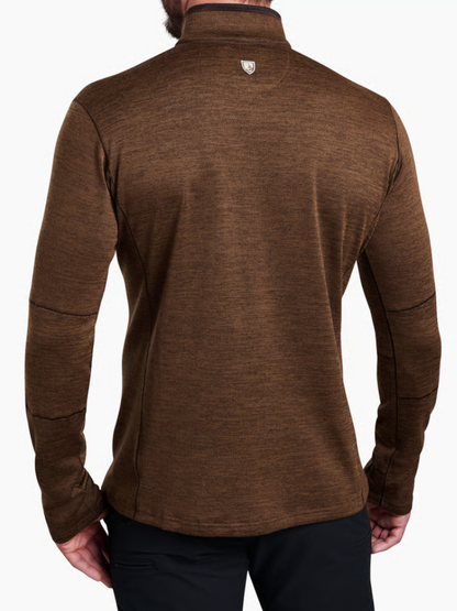 Back view of a man wearing a Kuhl Ryzer brown heathered quarter-zip pullover with a stand collar and a small shield logo on the upper back, paired with black pants.