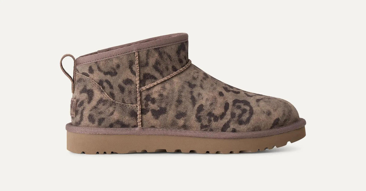 A single UGG Classic Ultra Mini ankle-height boot with a brown and beige leopard print pattern, featuring a pull tab on the heel and a thick brown sole, shown against a plain off-white background.