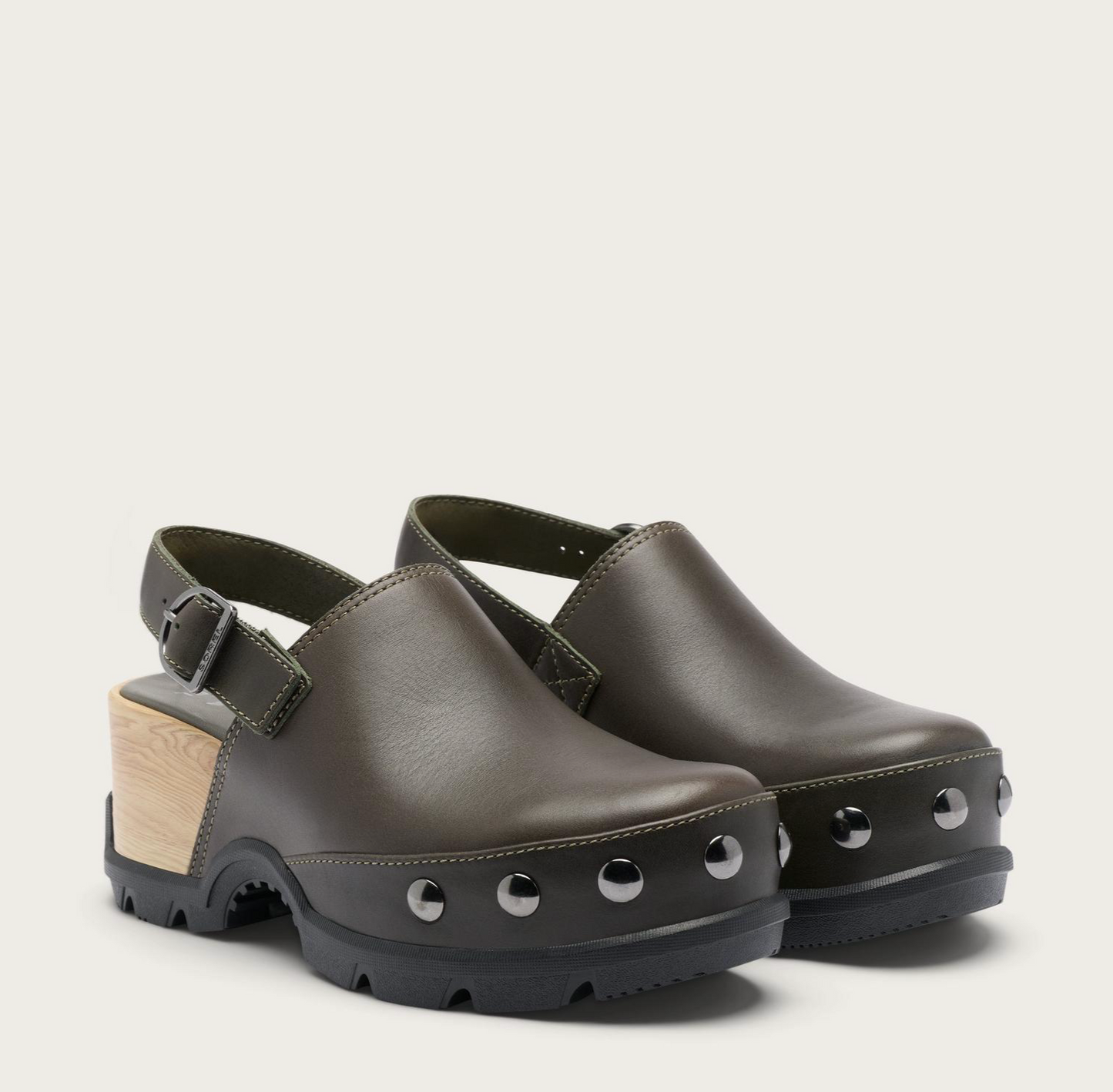 A pair of Sorel Roam’n dark olive green leather clogs with black soles, decorative silver studs, and light wood block heels, shown against a plain light beige background.