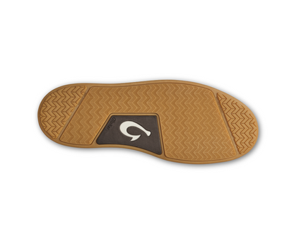 The bottom sole of a Okukai Kekaha boot, featuring a tan textured rubber tread with a dark brown central patch displaying the Olukai logo.