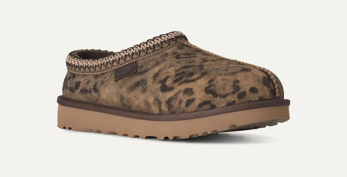 A single UGG Tasman Spotted clog-style shoe with a brown and tan leopard print upper, a braided trim around the opening, and a thick tan sole, shown on a plain light background.