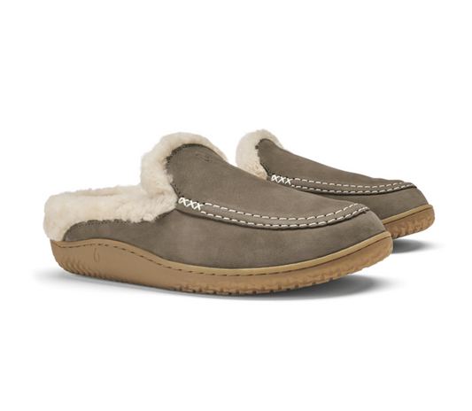A pair of Olukai Nohea Kolo slip-on mule slippers in taupe suede with a cream shearling lining and a tan rubber sole, shown on a white background.