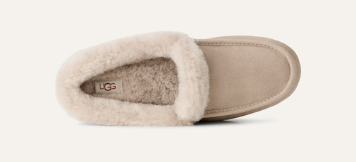 A single UGG Ansley slipper shown from a top-down view, featuring a beige suede upper, a soft cream shearling lining, and a light tan sole on a clean off-white background.