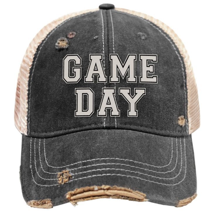 A distressed trucker-style baseball cap with a washed black front and brim, beige mesh back panels, and 'GAME DAY' embroidered in white block letters with black outlines across the front.