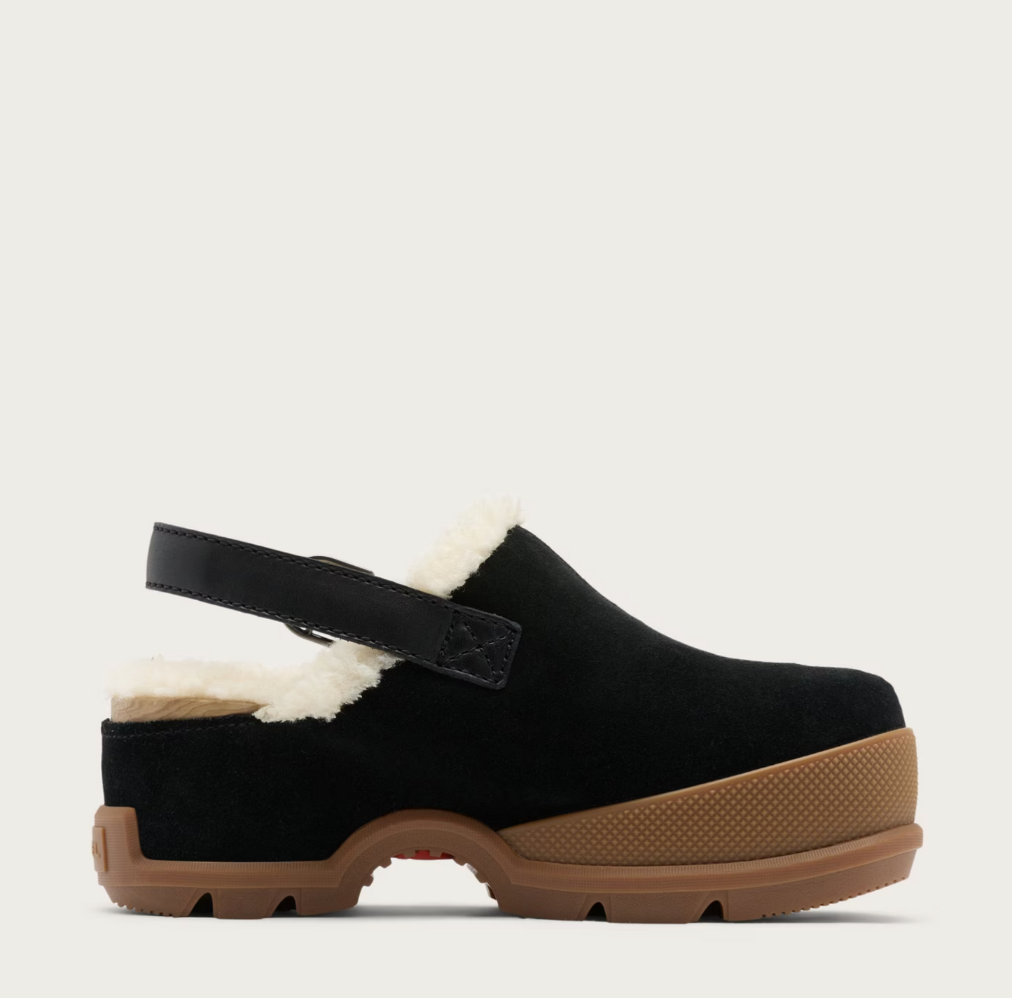 A Sorel black suede clog shoe with a white shearling lining, a black adjustable strap, and a brown textured sole, shown from a side profile on a light beige background.