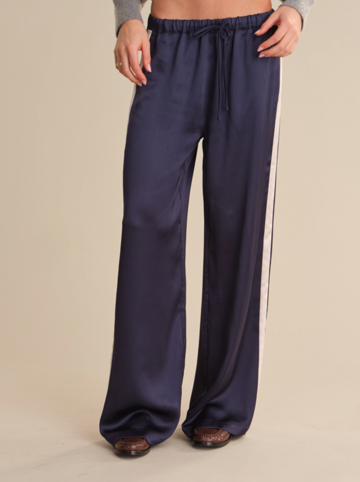 Dark blue knit, tie waist pant with contrasting side stripe and smooth, mid‑weight drape.