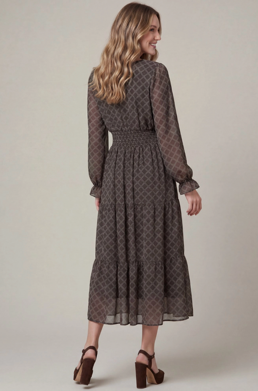A woman modeling a long-sleeve midi dress with a dark brown and gray geometric pattern, shown from the back against a neutral studio background.