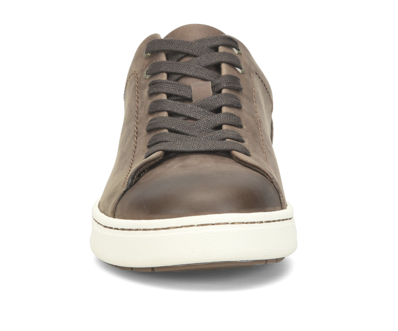 A single low-top leather sneaker shown from the front on a white background. The shoe features a medium brown leather upper, dark brown laces, and a thick white rubber sole.