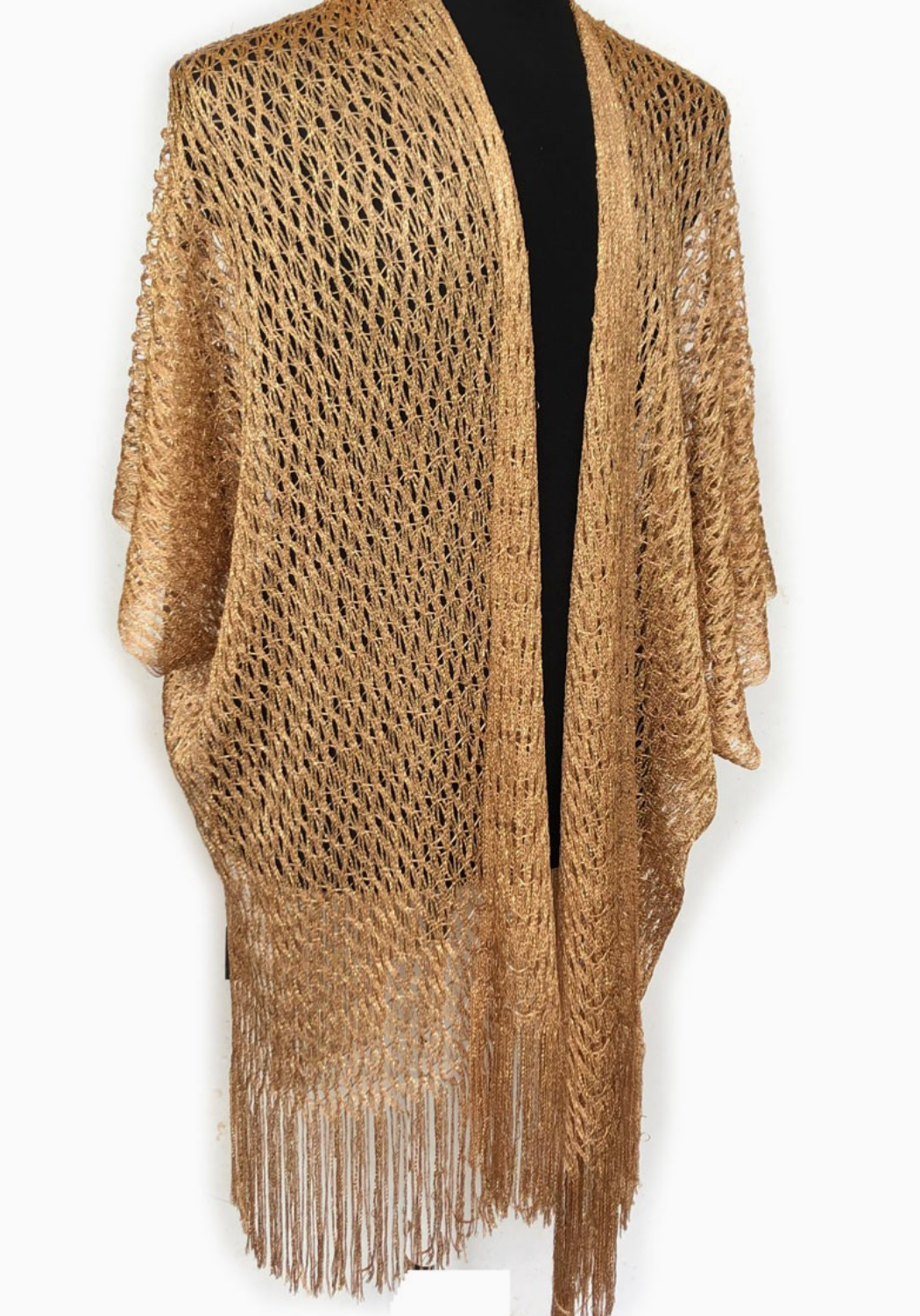 A gold open-knit poncho-style cardigan with a long fringe hem, displayed on a black dress form against a white background.