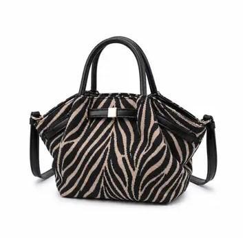An Urban Expressions zebra-print crossbody handbag with black leather handles and a black shoulder strap, shown against a plain white background.