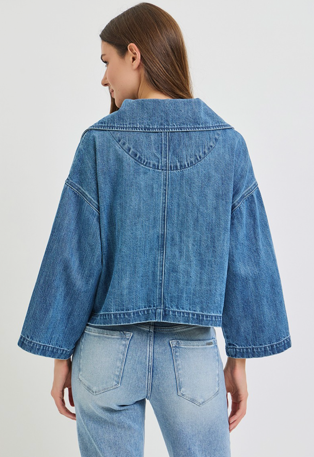 Risen cropped medium‑blue wash denim jacket with soft‑stretch fabric and button‑front styling.