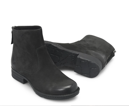 A pair of Born Mercado black ankle boots, one standing upright to show the side profile and zipper, and the other lying on its side to display the textured rubber sole, set against a plain white background.