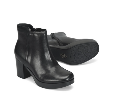 A pair of black leather Sofft Kendall  ankle boots with block heels, shown on a clean white background. One boot is positioned upright to show the side profile, while the other lies on its side to display the sole and embossed floral pattern.