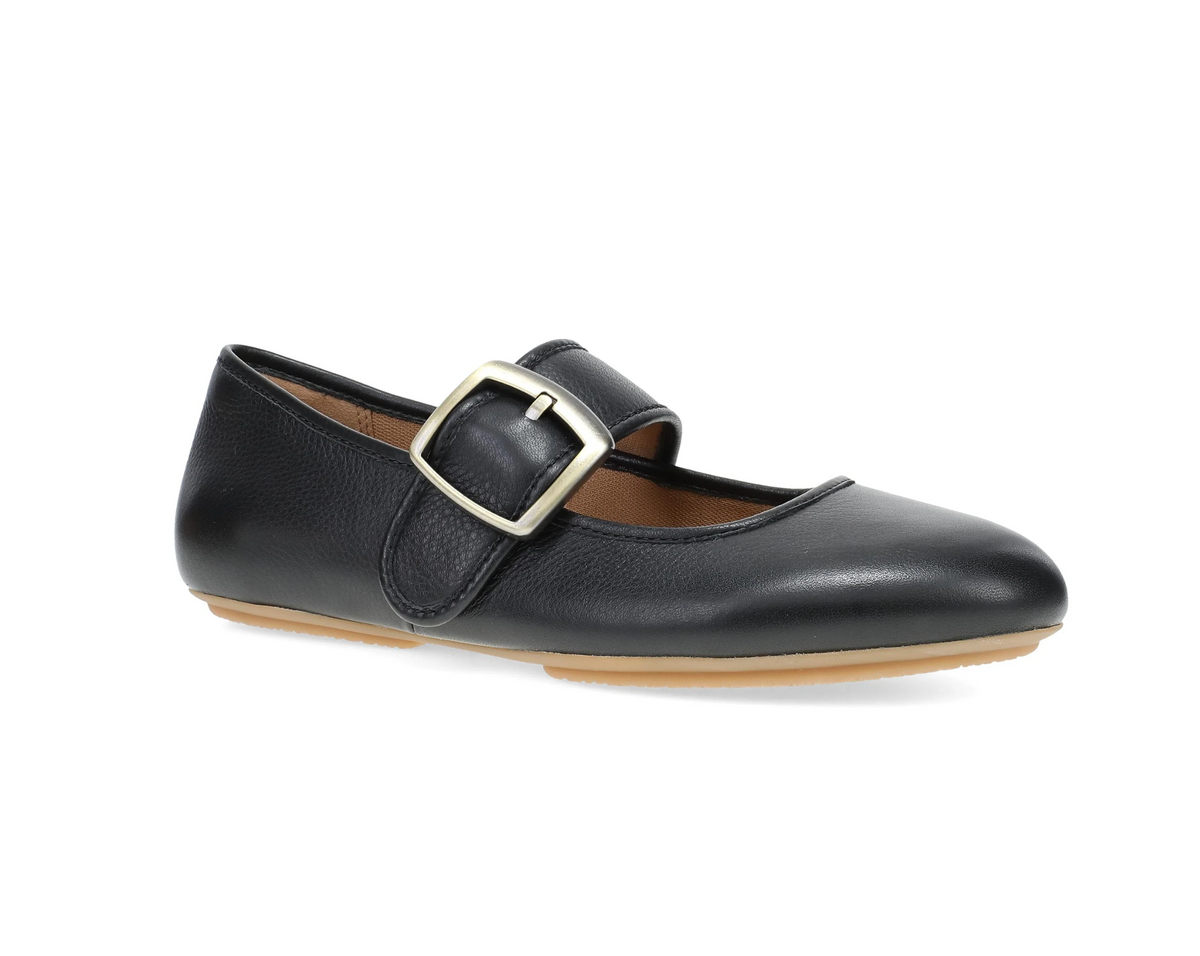 A Dansko black leather Mary Jane flat shoe with a silver-tone metal buckle strap, shown from a side profile on a white background.
