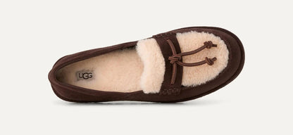 A single UGG Zora loafer in dark brown suede with a cream shearling lining and matching trim, shown from a side profile view against a light off-white background.