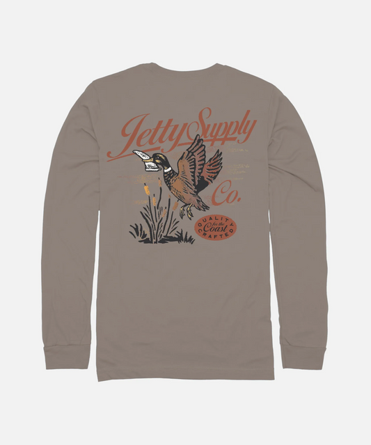 A long-sleeve t-shirt in taupe brown, shown from the back. The shirt features a graphic print of a flying duck with a surfboard on its back, the text 'Jetty Supply Co.