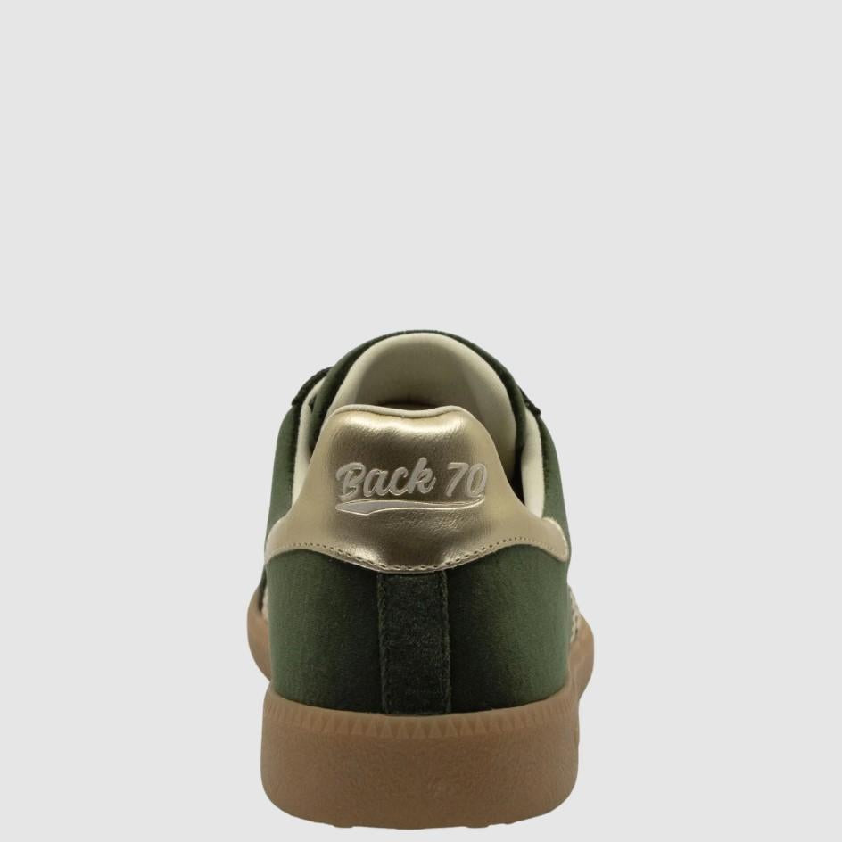 A rear view of a low-top sneaker in dark green suede and beige leather, featuring a gum brown sole and 'Back 70' embroidered on the heel tab, set against a light gray background.