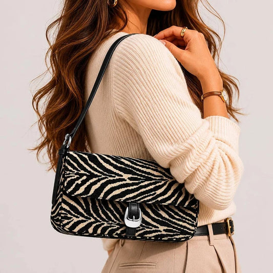Woman wearing a zebra patterned handbag with a plain background