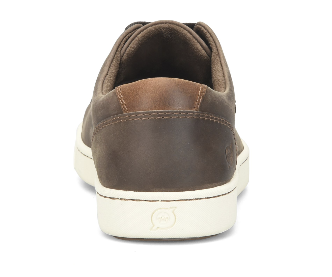 A brown leather low-top sneaker shown from the back, featuring a dark brown heel tab, matching brown collar, and a thick off-white rubber sole with a small embossed logo.