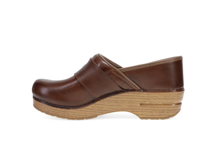 A single brown leather Dansko  clog shoe with a thick, layered natural wood platform sole, shown in a side profile view against a plain white background.