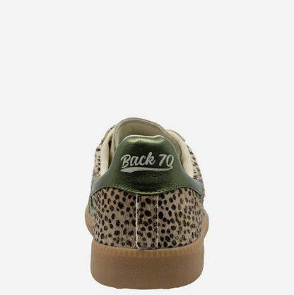 Rear view of a low-top Back 70 sneaker featuring a beige and black leopard print upper, a metallic olive green heel tab with 'Back 70' embroidered in white, and a tan gum sole.