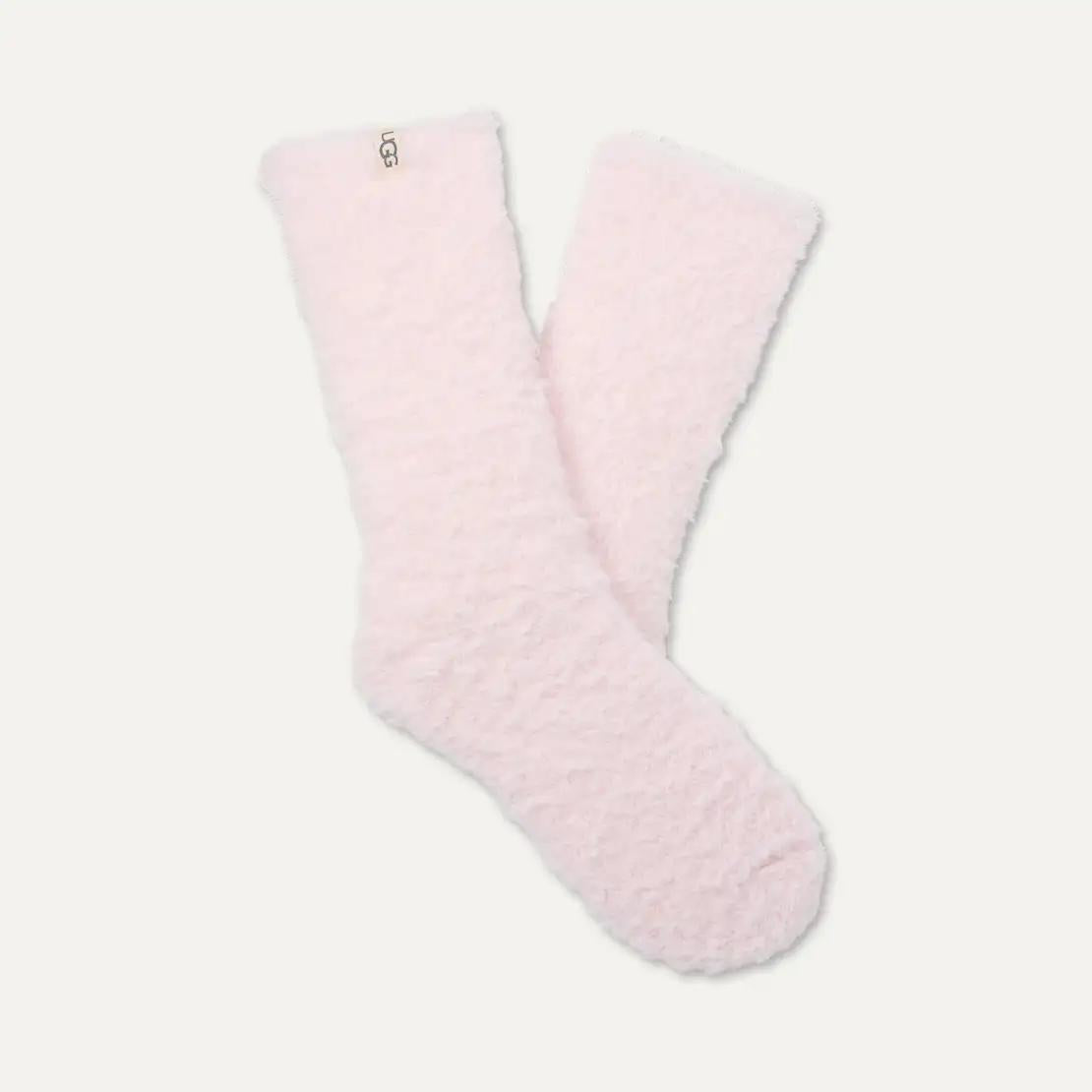 A pair of fluffy, textured light pink UGG Teddi Cozy crew socks with a small white UGG logo tag near the cuff, displayed on a clean off-white background.