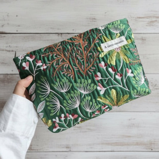 Green cosmetic bag with botanical floral print and zip‑top closure.
