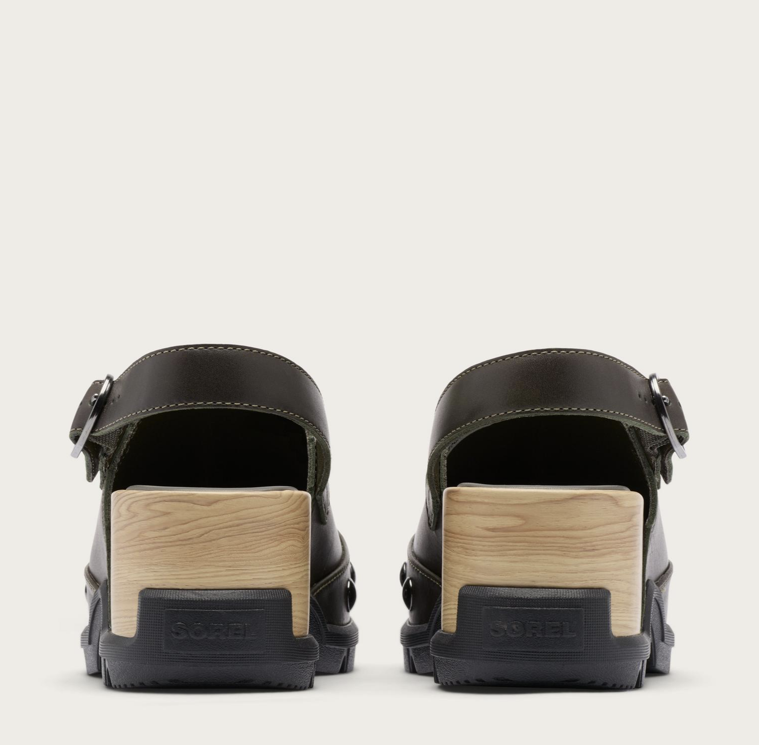 A pair of Sorel Roam’n dark olive green leather clogs with light wood block heels and black rubber soles, shown from the back on a light off-white background.