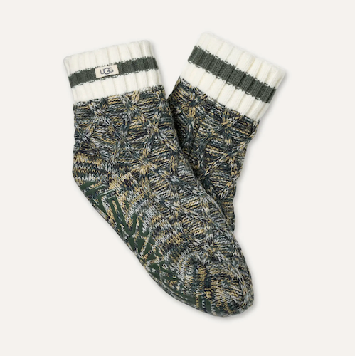 UGG knit crew socks with a dark green and beige cable-knit pattern, featuring white ribbed cuffs with dark green stripes and a visible UGG logo patch.
