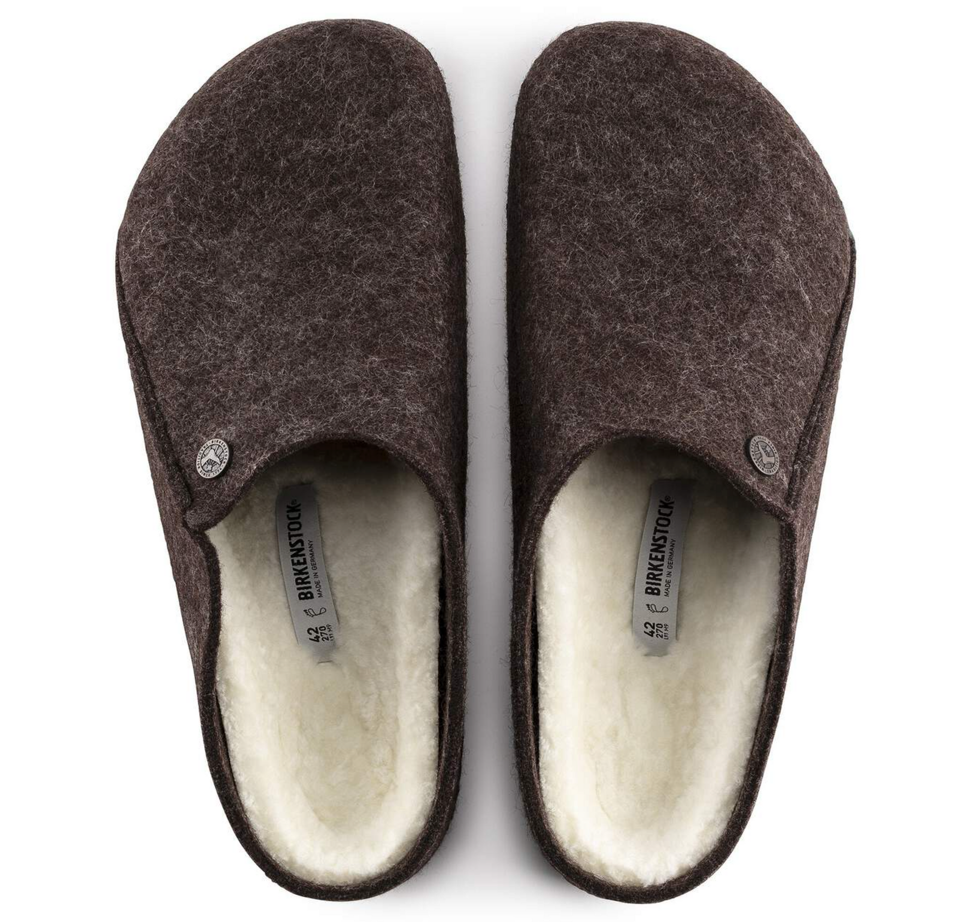 A pair of dark brown Birkenstock Zermatt Shearling clogs with a soft cream fleece lining, shown from a top-down view on a white background. The brand name 'BIRKENSTOCK' is visible on the inner labels.