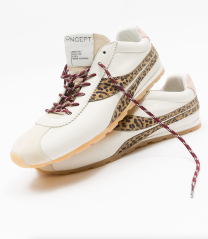 A pair of Oncept sneakers in off-white leather with leopard print side stripes, burgundy patterned laces, and a gum sole, photographed on a clean white background.