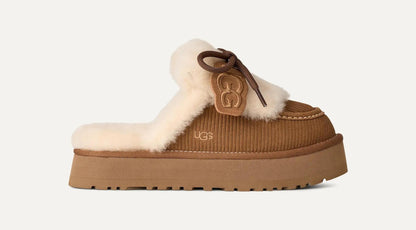 A single UGG Disquette Heritage mule slipper in brown corduroy with a cream shearling lining and a brown leather logo charm, shown against a light off-white background.