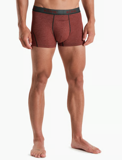 A man wearing heathered rust-brown Kuhl boxer briefs with a dark gray waistband, shown from the waist down against a plain white studio background.